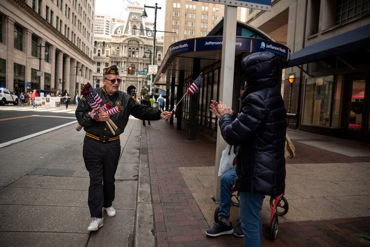 Vietnam veteran Joe Ferry, from Fairmount, passes out American flags during the 7th Annual Philadelphia Veterans Parade.