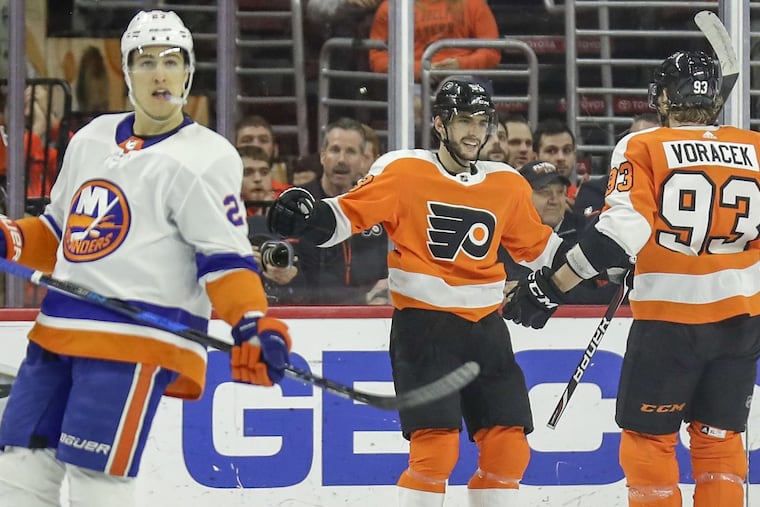 Flyers defenseman Shayne Gostisbehere celebrates his second-period goal with teammates right wing Jakub Voracek as New York Islanders left wing Anders Lee skates away on Friday, November 24, 2017 in Philadelphia. YONG KIM / Staff Photographer
