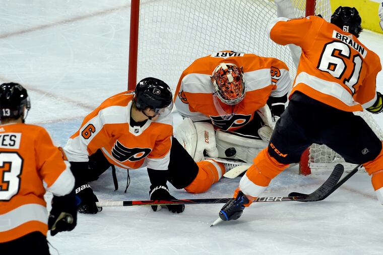 Flyers goalie Carter Hart has plenty of defensive help as he stops a Toronto Maple Leafs shot on goal during the first period of their game Tuesday at the Wells Fargo Center. From left are Kevin Hayes, Travis Sanheim, and Justin Braun.