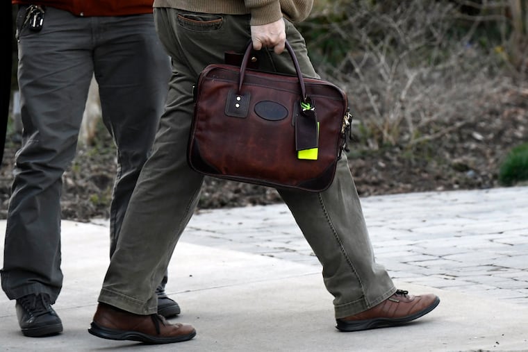 Attorney General William Barr carries his briefcase as he arrives at his home in McLean, Va., on Saturday evening. Barr scoured special counsel Robert Mueller's confidential report on the Russia investigation with his advisers Saturday, deciding how much Congress and the American public will get to see about the two-year probe into President Donald Trump and Moscow's efforts to elect him.