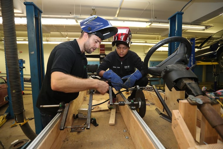 Jared Lauterbach, 11/12th grade advisor instructs Mang Sang, 17, how to bead weld a kinetic sculpture they are building at the Workshop School for the Kensington Kinetic Sculpture Derby, Wednesday morning May 16, 2018. DAVID SWANSON / Staff Photographer
