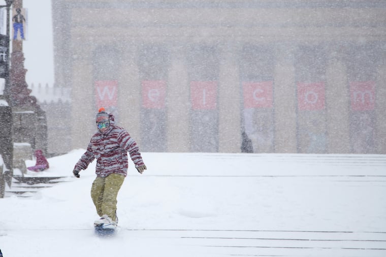Alex Yhr, 26, snowboards down the steps in front of the Philadelphia Museum of Art with his friend Miheer Pujara in Philadelphia, Saturday, Jan. 23, 2016. The two medical school student studying at Thomas Jefferson University decided to snow board the steps after seeing YouTube videos of people sledding there in 2015.