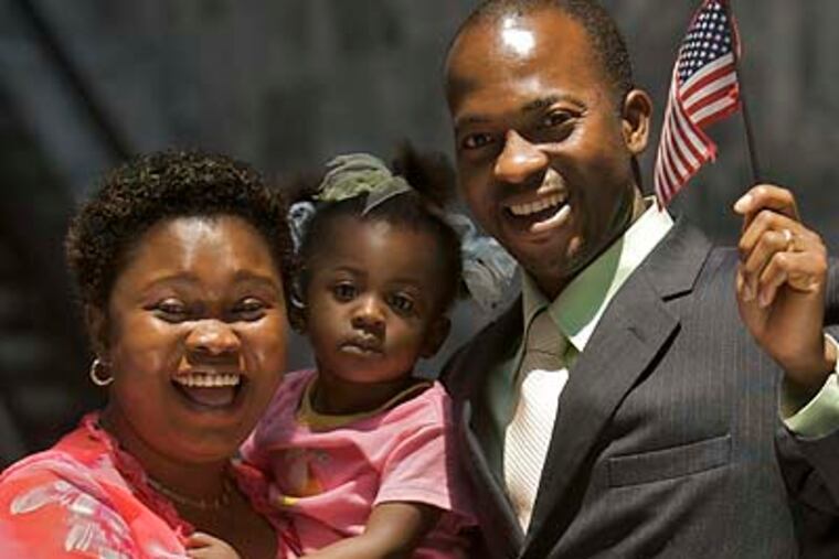 Lanre Simeon Sogbesan (right), formerly of Lagos, Nigeria, recently became an American citizen at a ceremony in Philadelphia. (John Costello / Staff Photographer)
