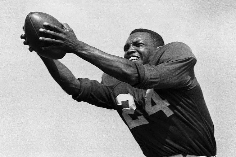 FILE - In this July 30, 1953, file photo, veteran halfback Wally Triplett of Penn State, a Cheltenham High School graduate, poses in action during his second year with Chicago Cardinals and fourth year in the National Football League. Triplett and a teammate broke the color barrier at the Cotton Bowl in 1948, and Penn State players will wear a helmet decal honoring him in Saturday's game against Memphis. (AP Photo/File)