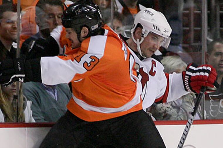 Dan Carcillo checks New Jersey's Jamie Langenbrunner during the third period. (Yong Kim/Staff Photographer)