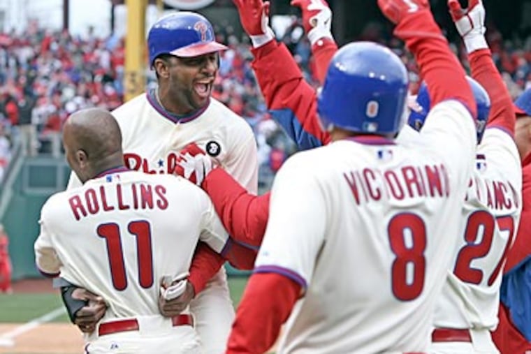 Ben Francisco gets mobbed by his teammates after scoring the game-winning run on Friday. (Steven M. Falk/Staff Photographer)