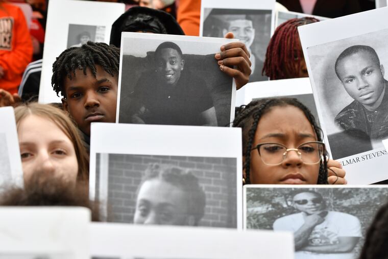 Philadelphia school students hold photos of gun violence victims at a March rally at the Pennsylvania Capitol calling for stronger gun laws.