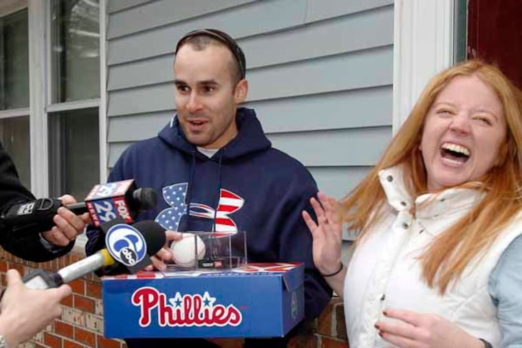 While Joey Andreacchio is talking to reporters, his girlfriend, Corrie Gorman reacts after Joey received Phillies season ticket from a mother of Phillies Phanatic, Phoebe Phanatic. AKIRA SUWA / Staff Photographer )