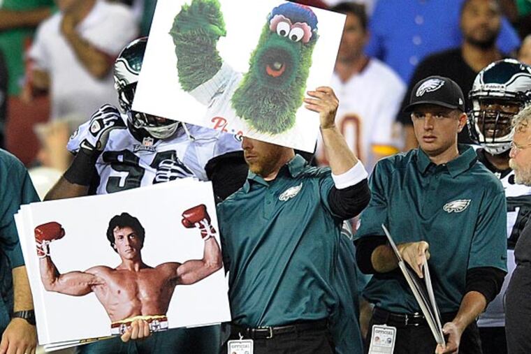 Philadelphia Eagles coaches using signs to set up plays. (AP Photo/Nick Wass)
