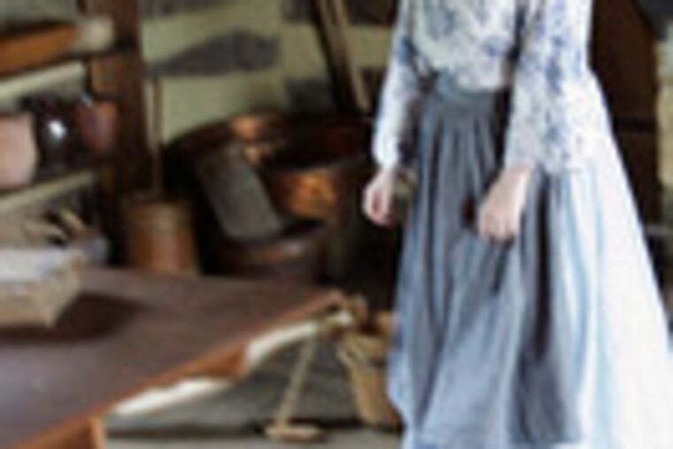 Davis shows off a cabin that recreates a combination tavern and courtroom.