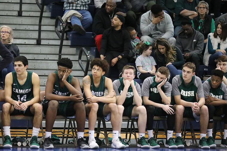 Camden Catholic coach Matt Crawford (standing) and players sit dejected near the end of their loss to Bergen Catholic on Saturday in the Non-Public A state final.