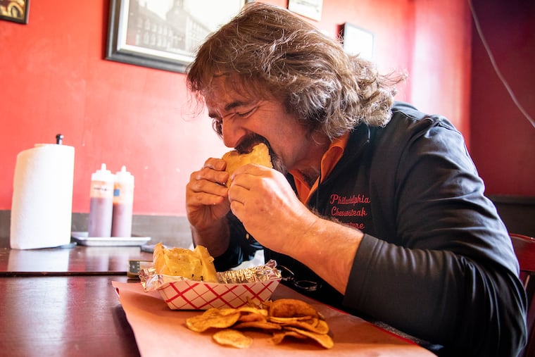 Jim Pappas, 56, of North Wilmington, Del., takes his first bite of the brisket cheesesteak from Mike's BBQ, marking his 500th cheesesteak on Wednesday, Jan. 8, 2020.
