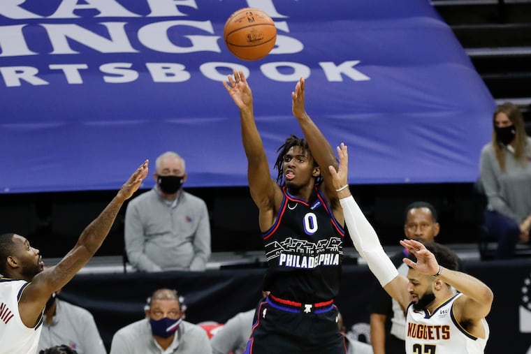 Sixers guard Tyrese Maxey shoots the basketball against Denver Nuggets guard Jamal Murray (right) and guard Will Barton on Saturday.