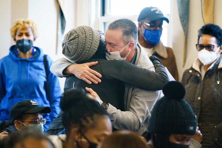 Police Chief Anthony Paparo, back center right, receives a hug from a resident at a Yeadon Borough Council meeting on Thursday.