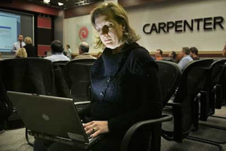 Kirsten Haas, commercial operations manager at Carpenter Technology Corp. in Reading, works on a laptop computer during an online webinar with out-of-town employees. Many companies are cutting back on company travel. (Laurence Kesterson / Staff Photographer)