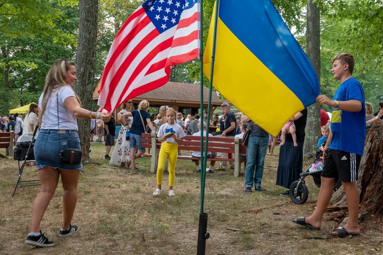 Anna Pisklarov (left, of Elmwood Park, N.J.) poses with the Ukrainian and American flags with her cousins Dima Shylo (right), 13, and Vika Seriekova (center, taking the picture), 10.