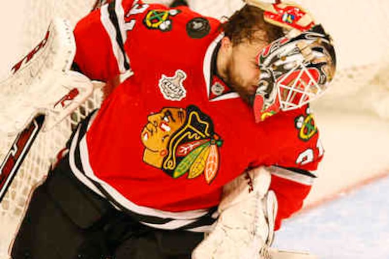 With his mask askew, Chicago's Antti Niemi comes up with a save. He made a key stop on Danny Briere's shot late in the game.