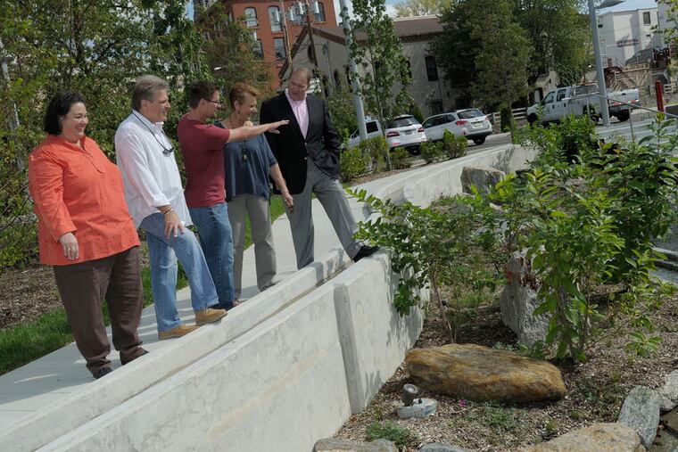 During a preview tour of Venice Island's $46 million makeover, Philadelphia Water Department resident engineer Jim Giffear (center) points out the features of the children's spray garden to (from left) Manayunk civic leaders Jane Lipton, Michael Rose and Kay Sykora, and Parks & Rec's deputy commissioner, Leo Dignam. (Photo by Gary Horn for the Daily News)