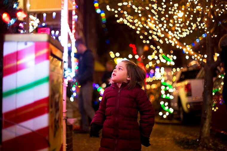 Penelope Garnant, 5, looks at Alex Khoa Du's home, which is decorated with lights and Santa Claus, as part of "Miracle on South 13th Street" Friday, November 25, 2016.