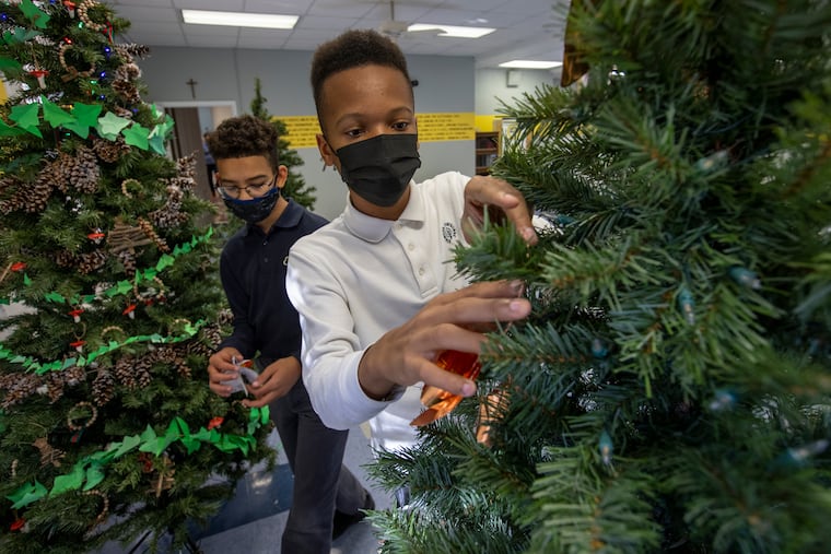 Joshua Harrington, 13, (right) and classmate Dalanie Franklin, 13, work together to decorate a Christmas tree at the Norwood Mansion, which is the centerpiece of the Chestnut Hill holiday house tour this year.