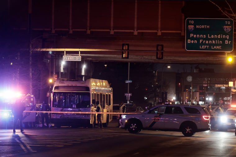 Philadelphia police investigate the scene at Washington Avenue and Front Street in Philadelphia where a SEPTA bus struck two people Friday night, killing a man and injuring his wife.