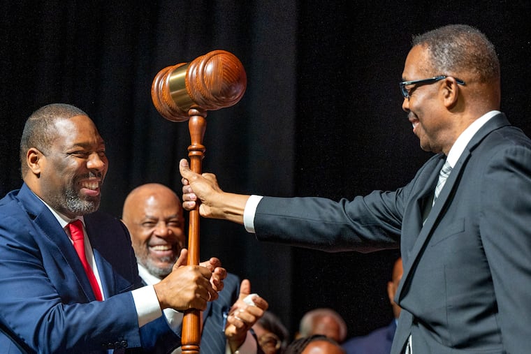 Outgoing Philadelphia City Council President Darrell Clarke, right, hands over an oversized gavel to newly-elected City Council President Kenyatta Johnson during inauguration ceremonies this month at the Met in Philadelphia.