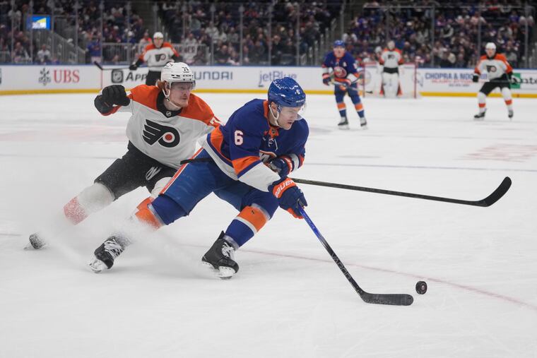 Flyers' Owen Tippett (left) fights for control of the puck with New York Islanders' Ryan Pulock during the first period of their matchup.