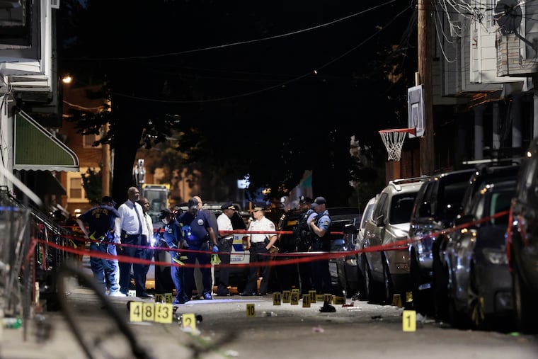 Police investigate the scene in the 1500 block of Etting Street after 13 people were shot just before 1 a.m. on July 7.