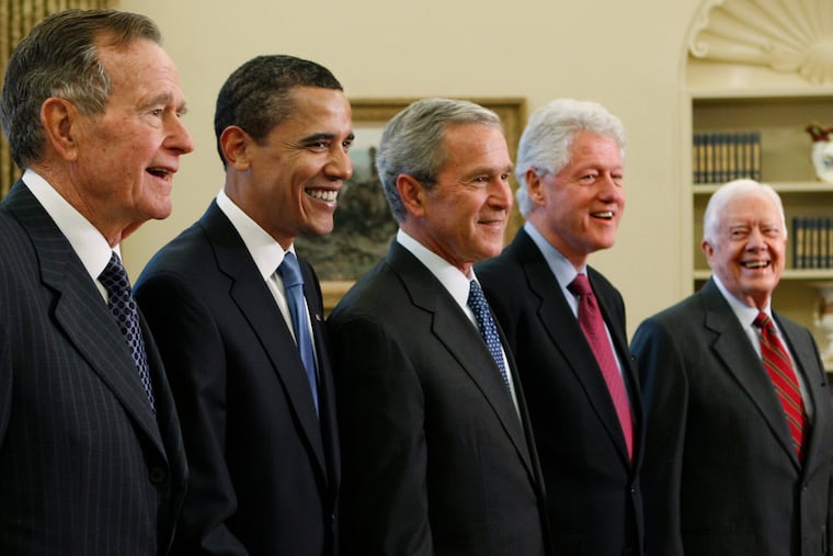 Then-President George W. Bush (center) poses with then-President-elect Barack Obama, and former presidents (from left) George H.W. Bush, Bill Clinton, and Jimmy Carter, Jan. 7, 2009, in the Oval Office of the White House in Washington. The younger Bush, Clinton, and Obama have contributed essays about presidents to the In Pursuit project.