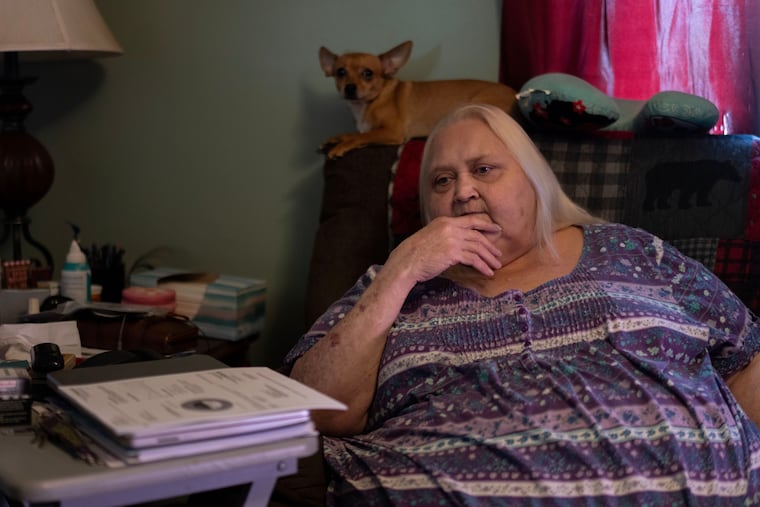 Rebecca Michalski pauses as she talks about electric bills she cannot pay while sitting next to her Chihuahua, Enos, at her home in Rainelle, W.Va., on March 21.