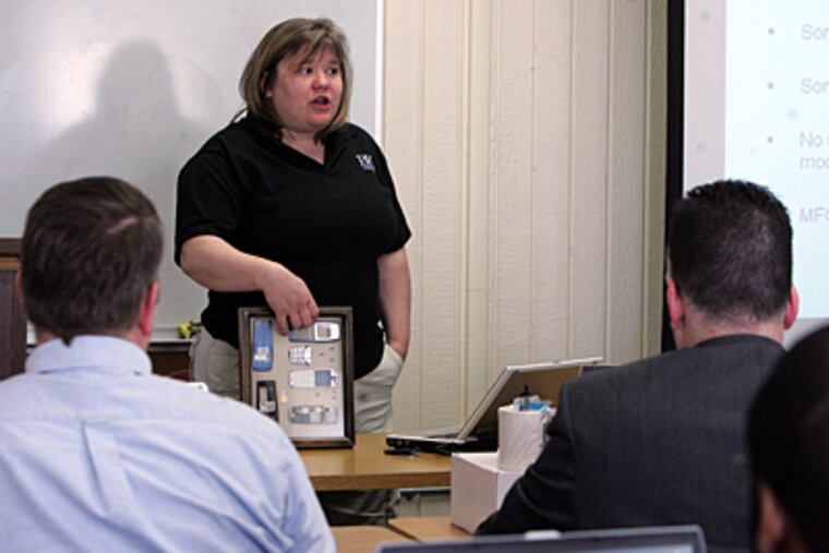 Detectives listen to Pam King of BK Forensics during a training session last month on extracting data from cell phones at the Delaware County Emergency Services Training Center in Sharon Hill. (Barbara L. Johnston/Inquirer)