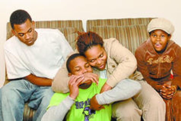 Sharonah Duckett-Thomas hugs son Keenan Wideman in their new home, with daughter Tyra Wideman and friend James Walker.