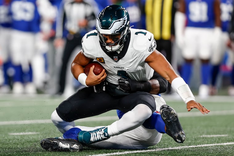 Eagles quarterback Jalen Hurts is sacked by Giants edge rusher Brian Burns during the Birds' 34-17 loss on Thursday night at MetLife Stadium.