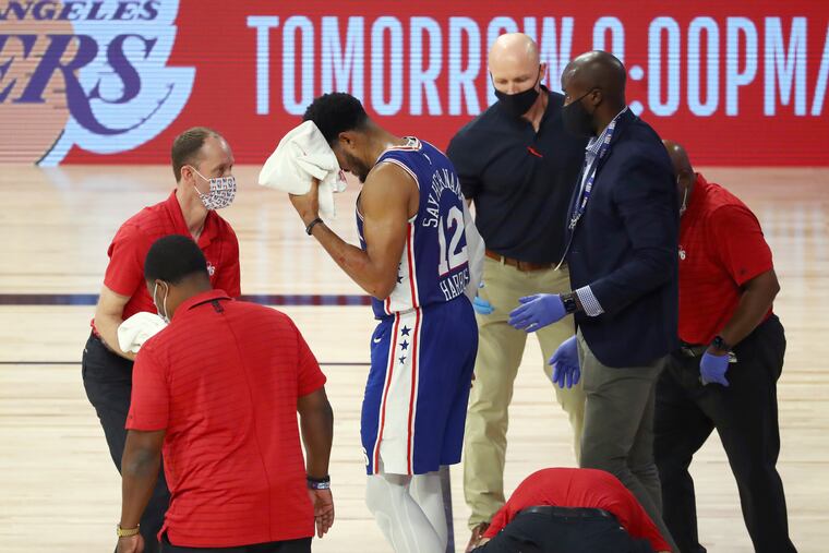 Philadelphia 76ers forward Tobias Harris (12) is attended to after hitting his head against the Boston Celtics during the third quarter of Game 4 of an NBA basketball first-round playoff series, Sunday, Aug. 23, 2020, in Lake Buena Vista, Fla. (Kim Klement/Pool Photo via AP)