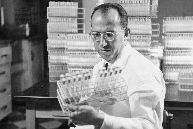 In this Oct. 7, 1954 file photo, Dr. Jonas Salk, developer of the polio vaccine, holds a rack of test tubes in his lab in Pittsburgh, Pa.