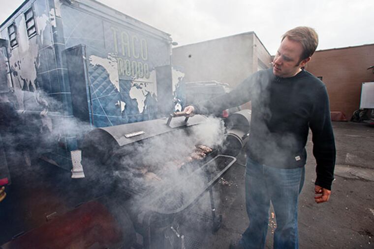 Michael Sultan, chef/owner of Taco Mondo and Street Food Philly trucks, checks on chicken in a smoker behind the Taco Mondo truck parked at the Bridesburg Commissary, Philadelphia, January 19, 2014. ( DAVID M WARREN / Staff Photographer )