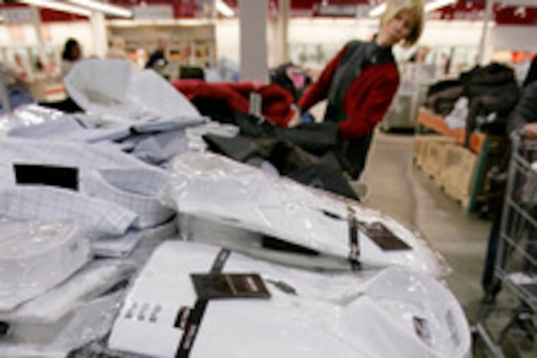 Men's shirts get a careful look at a Costco store in Mountain View, Calif. Consumers stormed the malls, pushing up sales in November.