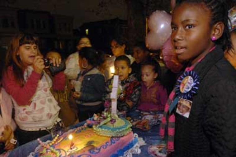 In Philadelphia, grieving friends and neighbors throw an 11th birthday party for Charlenni Ferreira. Here, Charlenni's best friend Cheyenne Roundtree, 11, at right, sings happy birthday around a cake. ( April Saul / Staff Photographer )