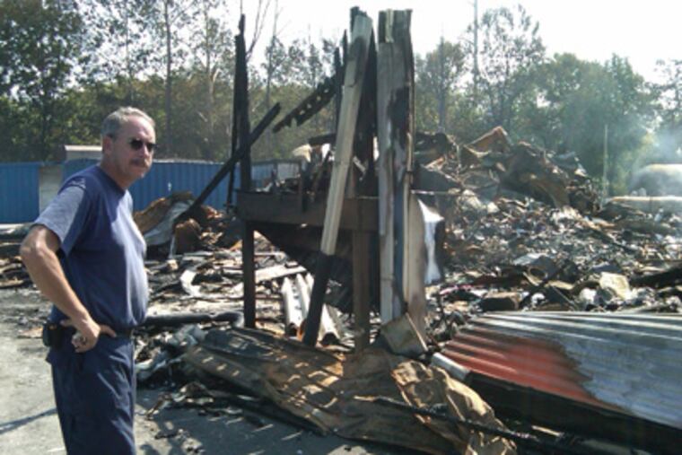 George Kaiser looks over the smoldering remains of his business after the Delco propane fire. (Mari Schaefer / Staff Photographer)