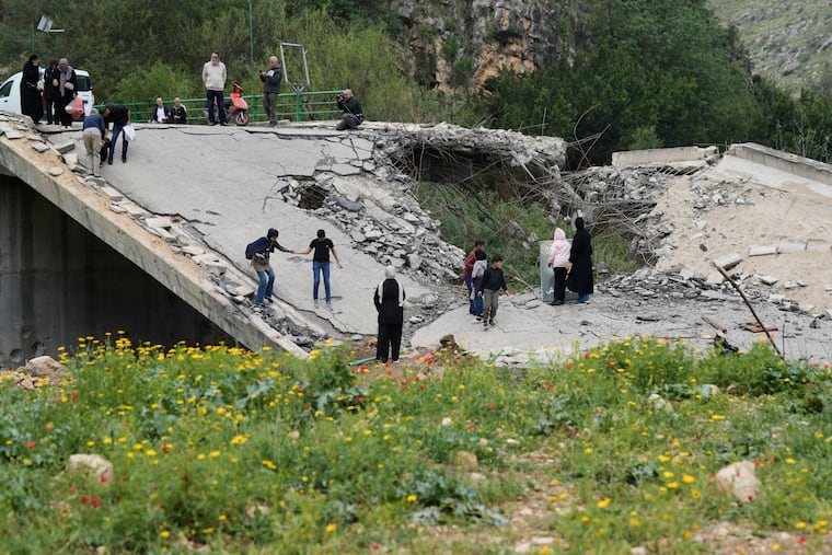 Displaced people cross on foot over a destroyed bridge Sunday as they return to their villages near the city of Tyre in southern Lebanon following a ceasefire between Hezbollah and Israel.