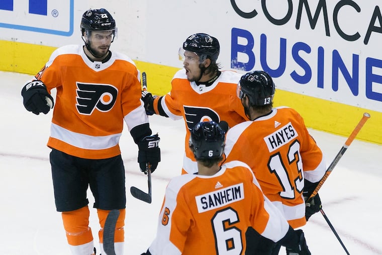 Flyers left winger Scott Laughton (21) celebrates his third-period goal alongside linemates Travis Konecny (11), and Kevin Hayes (13), along with defenseman Travis Sanheim (6) during Thursday's 3-1 round-robin win over the Capitals. Hayes and Laughton (two goals) each had three points.