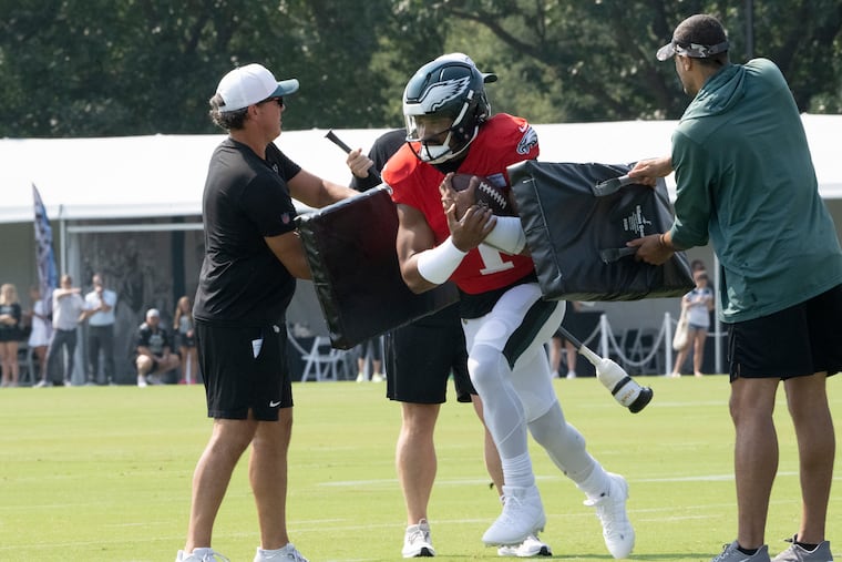 Eagles quarterback Jalen Hurts carries the football through a drill during training camp practice on Monday.