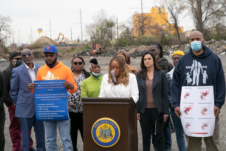 Councilmember Jamie Gauthier (center) holds a press conference against a backdrop of a dumping site in West Philadelphia on Thursday.