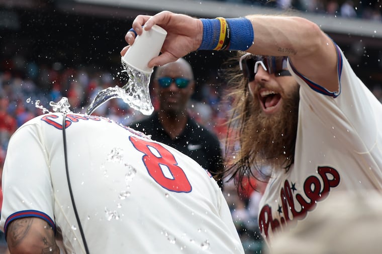Brandon Marsh pours a cup of water on Nick Castellanos during a postgame interview following a win over the Rockies on Saturday.