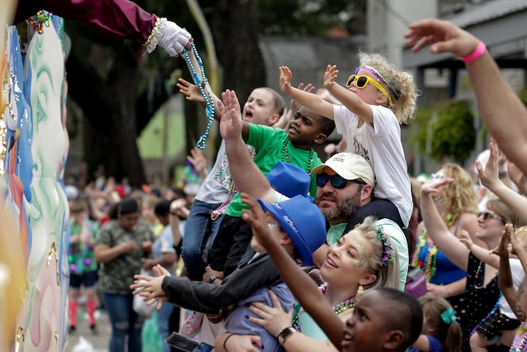 Revelers reach for beads and trinkets as the Krewe of Thoth rolls on the Uptown route in New Orleans Sunday, March 3, 2019, to the theme, 'Thoth Salutes the Greats.' Douglas Rushing reigned as king and Madison Komnecker as queen over 1,800 male riders on 39 floats. Founded in 1947, the Krewe of Thoth is named for the Egyptian Patron of Wisdom and Inventor of Science, Art and Letters. (Scott Threlkeld/The Advocate via AP)