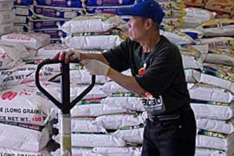 Jum Lai unloads rice from a truck at the Hung Vuong Supermarket in South Philadelphia. (RON TARVER / Inquirer)