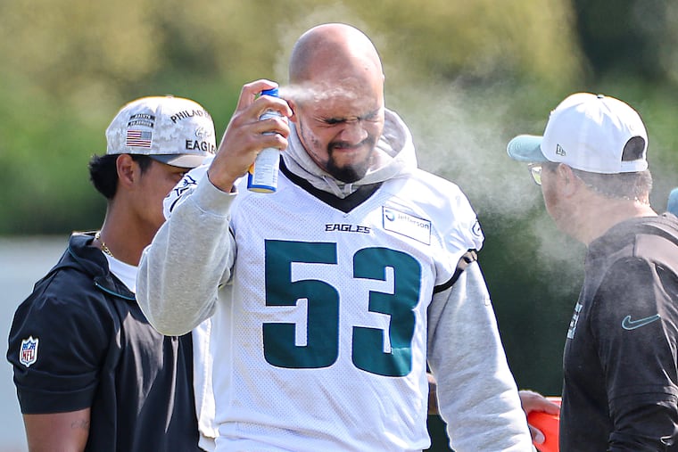 Eagles linebacker Zack Baun applies sunscreen during the training camp session Sunday at the NovaCare Complex.