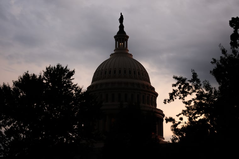 The sun sets behind the U.S. Capitol in July in Washington.