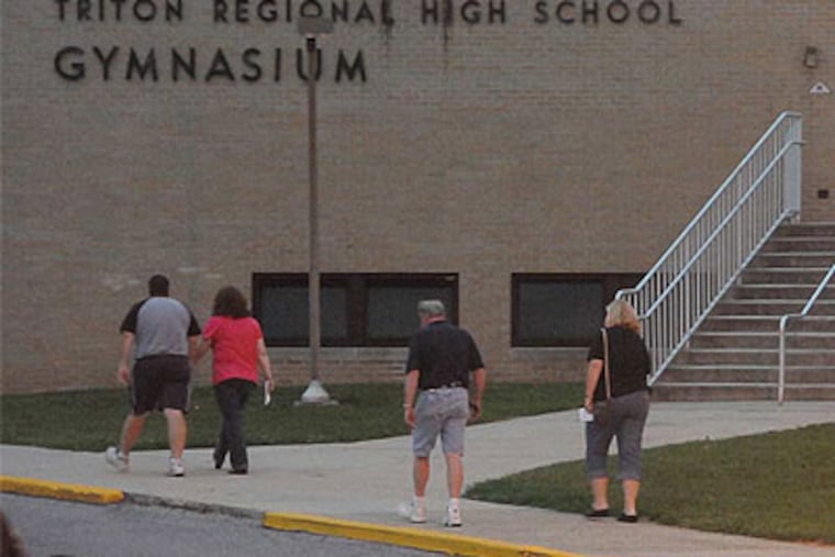 People walk toward Triton Regional High School in Runnemede, N.J. for Back-to-School night. (Curt Hudson / For the Daily News)
