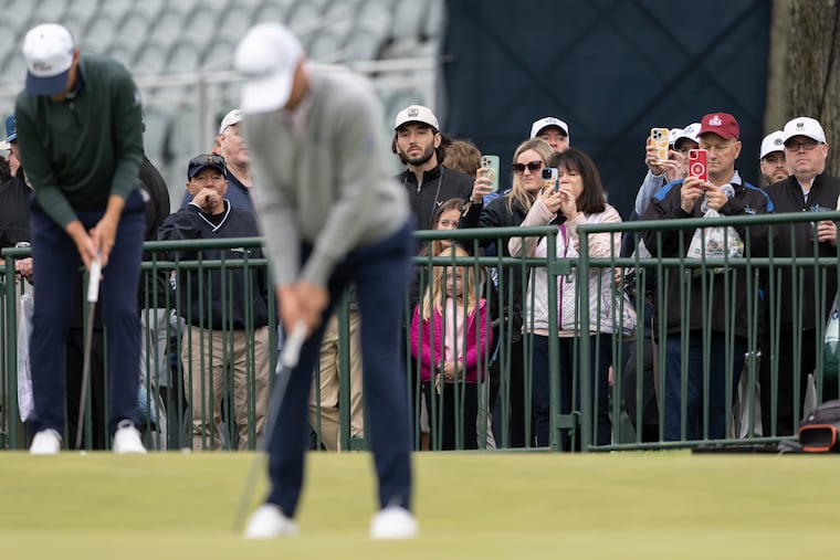 Fans watch as Justin Thomas works on his putting Monday at Aronimink Golf Club, ahead of this week's PGA Championship.